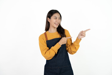 Young beautiful woman with apron standing on isolated white background pointing finger to blank space.