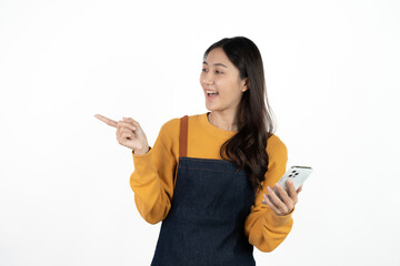 Happy young asian woman business owner wear apron and holding smartphone for checking order from...