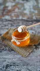 Fresh honey in a jar. Stick for honey. Harvest of honey. Flower honey.