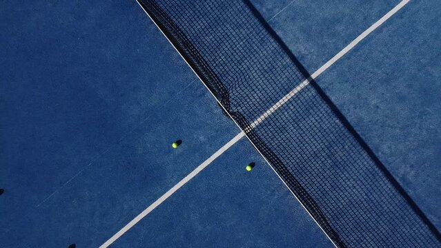 upward drone video footage on a blue paddle tennis court, sports courts