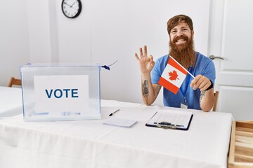 Caucasian man with long beard at political campaign election holding canada flag doing ok sign with...