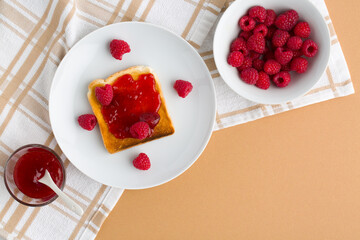 Cup of red tea and toasted bread with raspberry jam