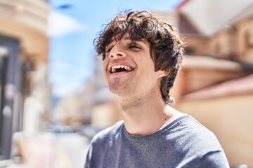 Young hispanic man smiling confident standing at street