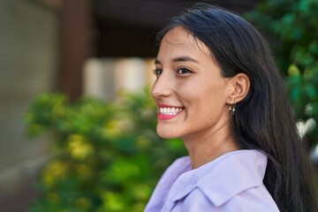 Young beautiful hispanic woman smiling confident looking to the side at street