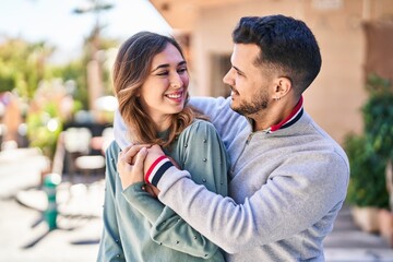 Man and woman smiling confident hugging each other standing at street