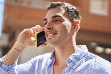 Young hispanic man smiling confident talking on the smartphone at street