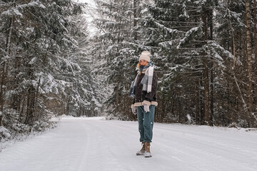 Winter.woman walks through winter snowy forest. Mental and physical health. Unity with nature.travel outdoors, hiking, spending time outdoors,winter travel,slow life,christmas forest.