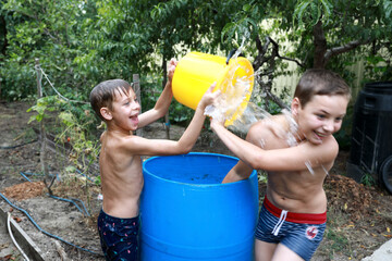 Kids pour water on each other in backyard