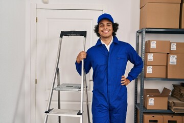 Obraz premium Young hispanic man technician holding ladder standing at office