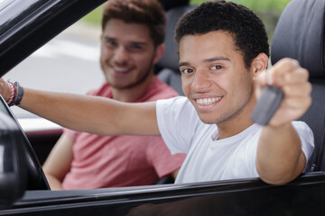 young man sitting at the front seat showing keys
