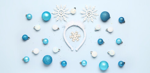 Stylish Christmas headband and beautiful balls on light blue background