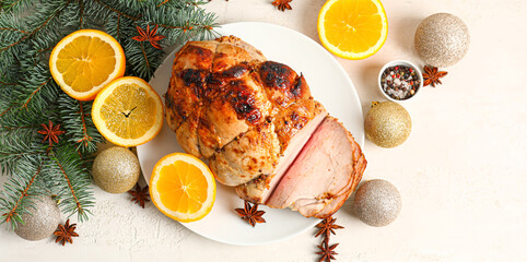 Plate with tasty ham, orange fruit and Christmas decor on light background