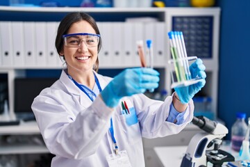Young woman scientist holding test tubes at laboratory