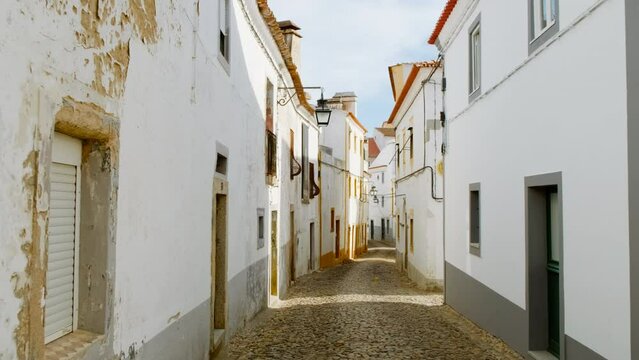 Discovering the narrow and picturesque streets of Evora, Portugal, featuring the famous whitewashed houses with yellow accents