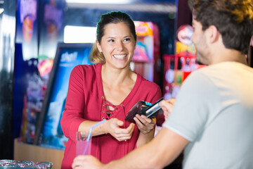 young woman paying with credit card in cafe