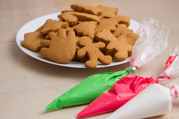 christmas gingerbread and colored icing in bags on the table