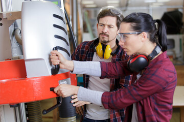 man and woman with machine cnc in factory