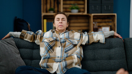 Middle age hispanic woman relaxed sitting on sofa at home