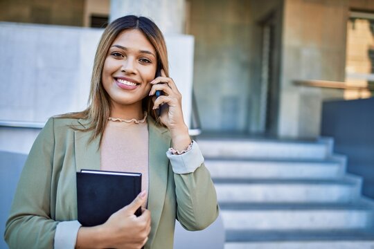 Young latin woman smiling confident talking on the smartphone at street