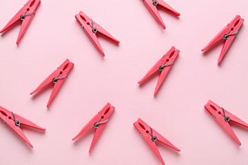 Many plastic clothespins on pink background