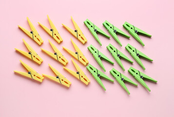 Different plastic clothespins on pink background