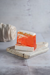 Hand made honey comb orange soap soft light minimalistic style on white wood board and linen towel 