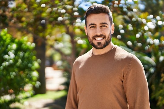 Young hispanic man smiling confident standing at park