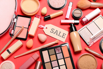 Bag with cosmetic products, accessories and sale tag on red background