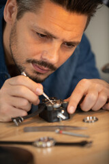 close-up of young man repairing wrist watch at desk