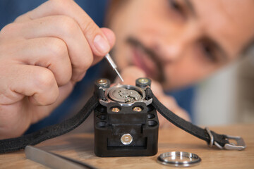 Obraz na płótnie Canvas man repairing wristwatch at the workshop