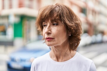 Middle age woman looking to the side with serious expression at street