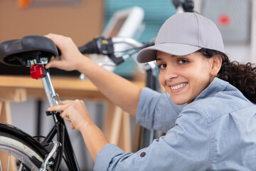female mechanic with spanner working on bicycle