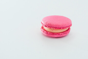 Pink French macaroon isolated on white background. Tasty colourful macaroons. Cookie made of two smooth halves, fastened with stringy fillings. French pastry made from egg whites.