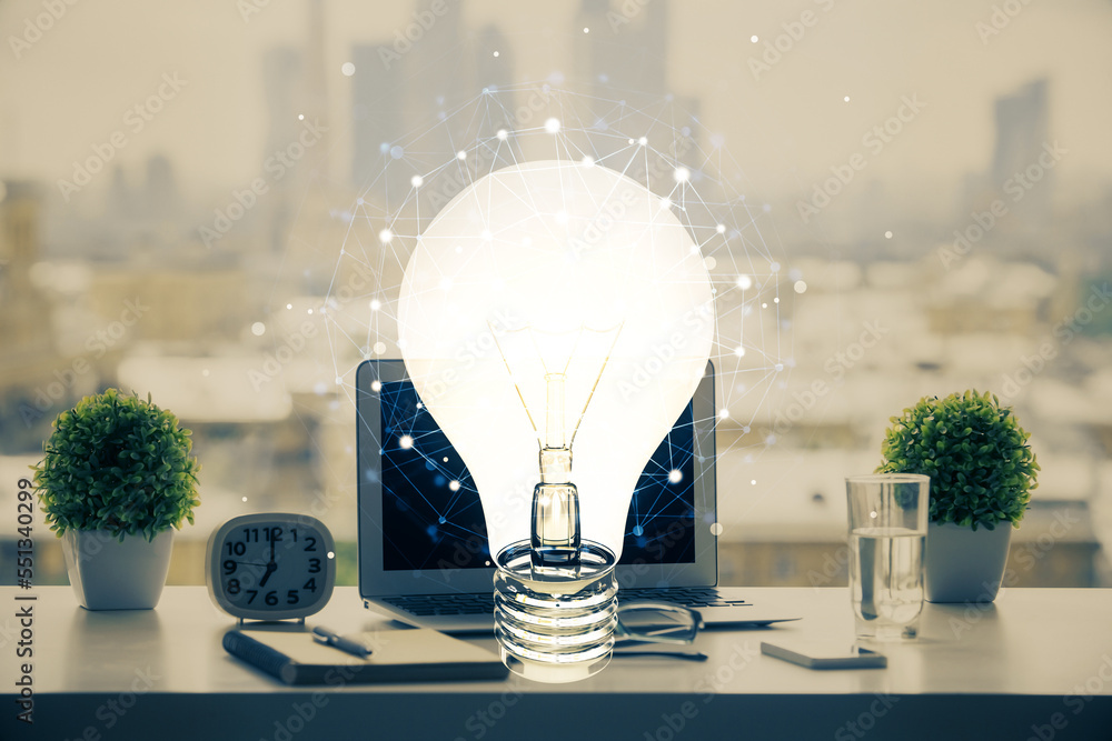 Poster Computer on desktop in office with bulb icon hologram. Double exposure. Concept of idea.