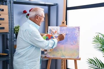 Senior grey-haired man artist smiling confident drawing at art studio