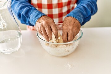Senior man cooking dough at kitchen