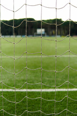 Close-up of the net of an empty soccer goal. Vertical soccer stadium through the goal