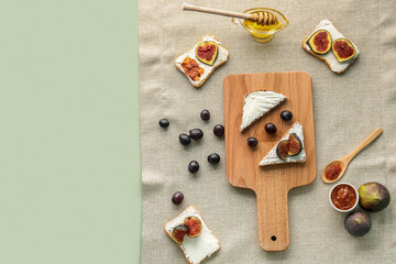 Composition with tasty bruschettas, fruits and honey on color background