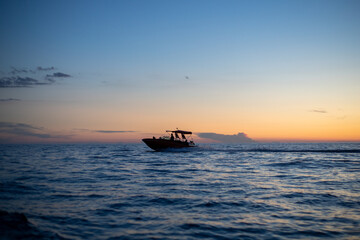 motorboat silhouette racing into the sunset