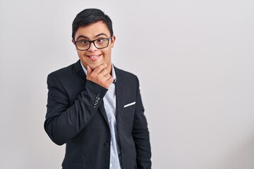 Young hispanic man with down syndrome wearing business style looking confident at the camera smiling with crossed arms and hand raised on chin. thinking positive.