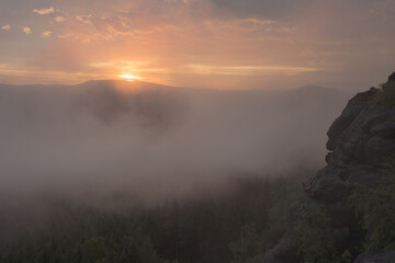 Zum Sonnenuntergang zieht Nebel durch das von Bergen umsäumte Tal. Nachtmittags regnete es. Das letzte Licht färbt die dunkeln Wolken. Mit Einbruch der Dunkelheit lösen sich die Nebelschwaden auf.