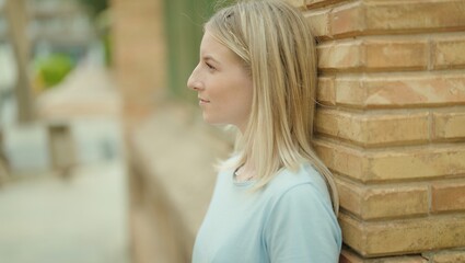 Young blonde woman looking to the side with serious expression at street