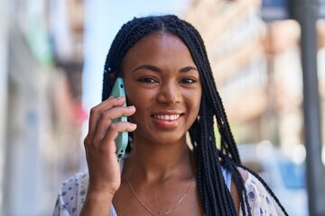 Fototapeta premium African american woman smiling confident talking on the smartphone at street
