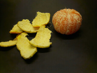 peeled citrus fruits on a black background