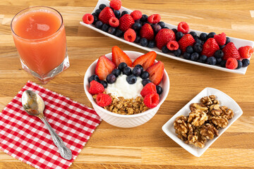 Healthy breakfast, yogurt with strawberry, blueberry, raspberry, walnut, juicie and cereal