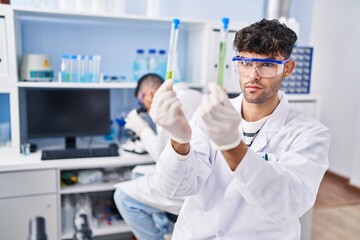 Two man scientists holding test tubes working at laboratory