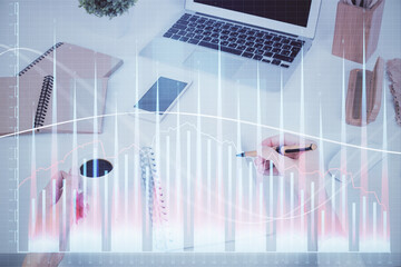 Hands writing information about stock market in notepad. Forex chart holograms in front. Concept of research. Multi exposure