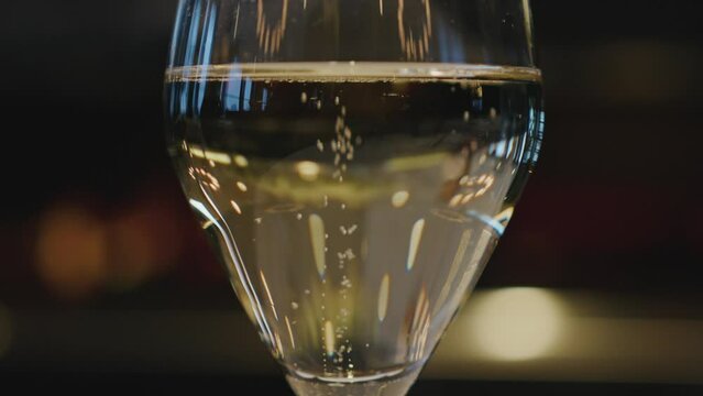 Champagne bubbles slowly rise to the top of the glass