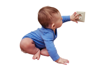 Baby toddler reaches into the electrical outlet on the home wall with his hand, isolated on a white background. Danger and protection of child fingers from electric shock