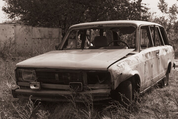 Countryside. Destroyed civilian car stands on the side of the road